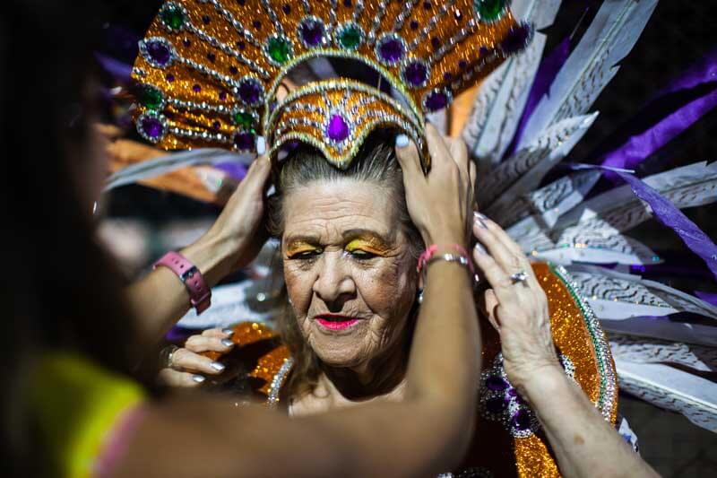 Desde temprano, en el Centro de Jubilados, observamos la emoción de las comparseras mientras ultiman detalles de maquillaje y vestuario.