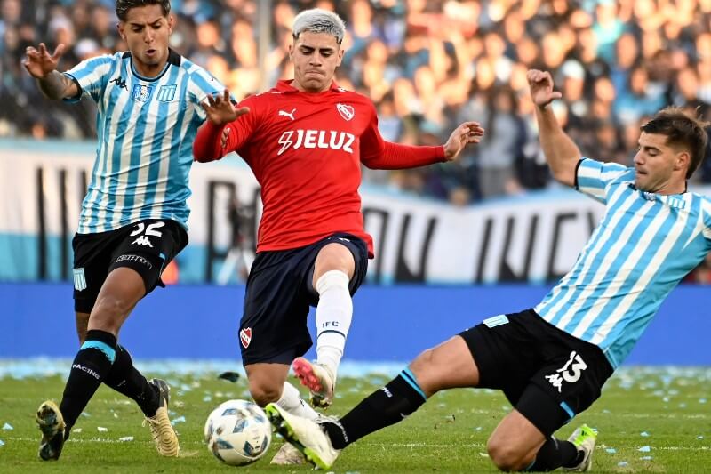 Independiente resistió los ataques de Racing durante un intenso clásico en Avellaneda, logrando un empate celebrado como victoria. A pesar de jugar con un hombre menos durante casi una hora y terminar con nueve jugadores, la actuación sobresaliente del arquero Rodrigo Rey evitó la derrota. La Academia, aunque dominó y realizó 18 remates, no logró superar la resistencia rival, dejando a su hinchada entre aplausos y silbidos.