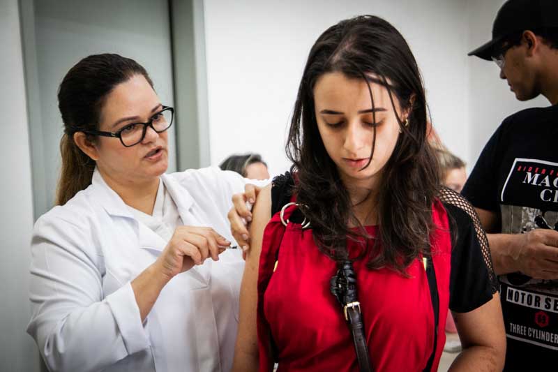 La vacuna está contraindicada en personas gestantes, niños menores de 6 meses, personas con antecedentes de reacción alérgica grave (anafilaxia) a los componentes, inmunocomprometidas, con infección de VIH, con inmunosupresión por drogas, trasplantadas de órganos sólidos o precursores hematopoyéticos. Entre los síntomas están fiebre alta, tos, rinorrea y una erupción cutánea que se extiende por todo el cuerpo.