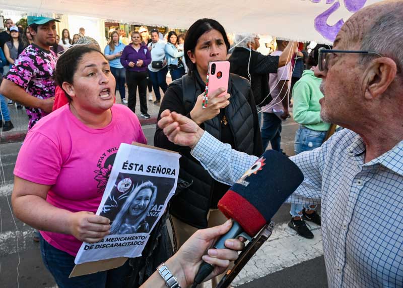 Una mujer, entre los manifestantes presentes, expresa su descontento durante la previa a la marcha donde hubo disturbios.