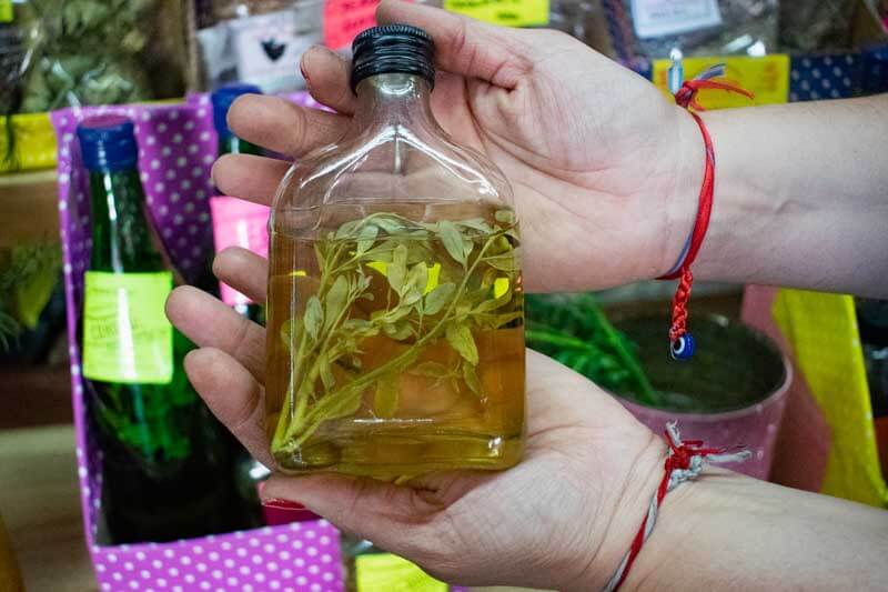 La receta es sencilla: una ramita de ruda macho, reconocida por sus hojas grandes y fuerte aroma, se introduce en una botella pequeña con caña blanca, la tradicional. No se prepara en el momento de consumo, sino con anticipación; algunos lo dejan macerar en el licor hasta un mes antes.