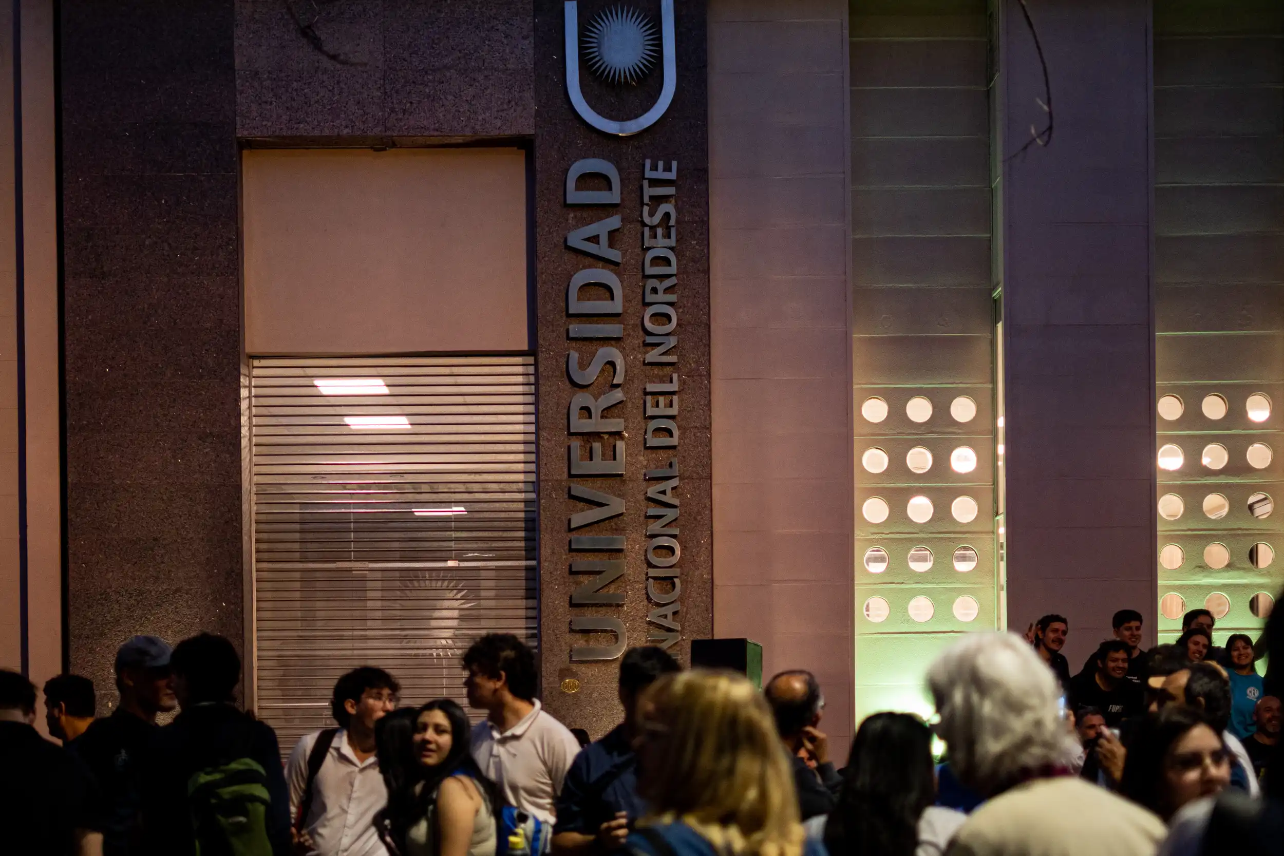 Con la llegada de la noche, la concentraci&oacute;n se acercaba a su cierre frente a la sede de la Universidad Nacional del Nordeste (UNNE). La iluminaci&oacute;n del edificio y la presencia de quienes permanec&iacute;an en el lugar registraron el &uacute;ltimo tramo de una jornada.
