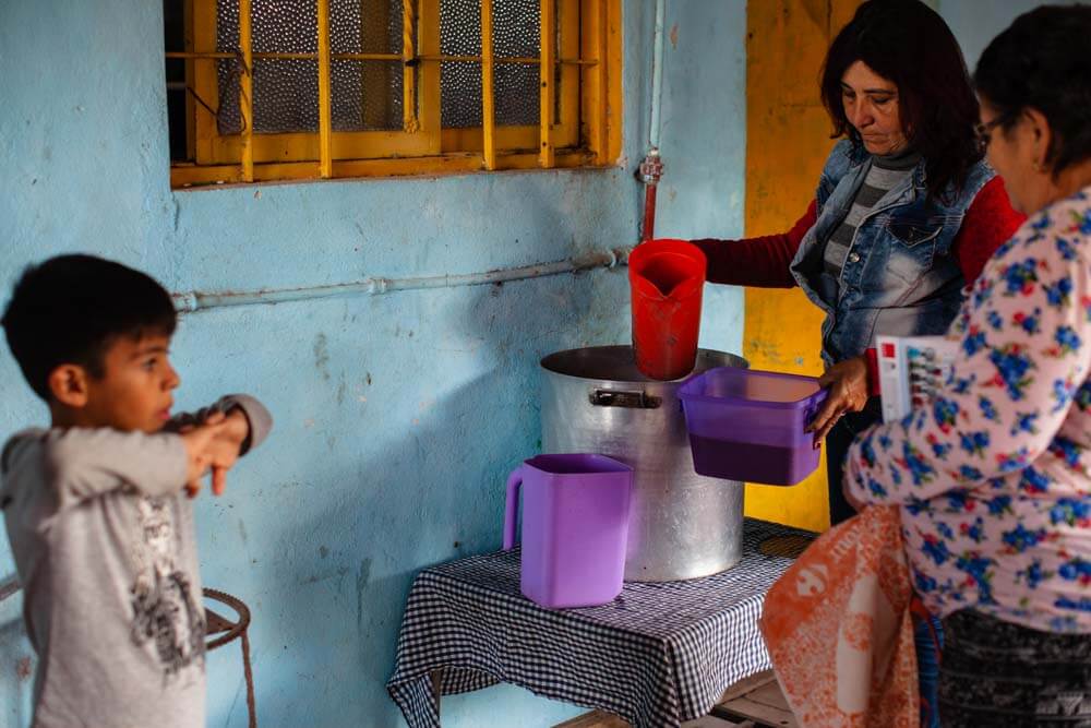 En un rincón alejado el amor se transforma en comida, creando un lazo entre quienes dan y quienes reciben en cada merienda compartida.