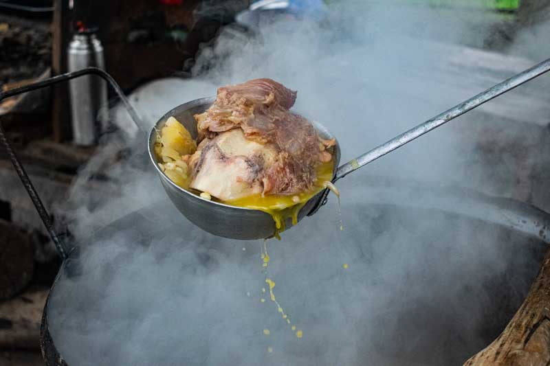 Su nombre viene del quechua ruqru, y aunque la receta varía según el país o la región, el concepto es el mismo: un guiso espeso, nutritivo y popular que mezcla maíz, legumbres, verduras y carne en una cocción lenta y comunitaria.