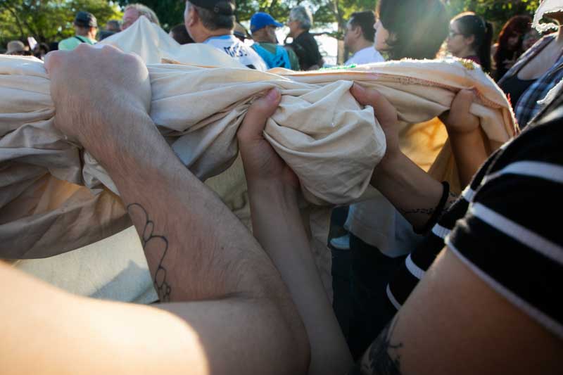 La tela de una pancarta gigante fue sostenida con firmeza por decenas de manos, tensada en conjunto como una imagen de unidad y persistencia.