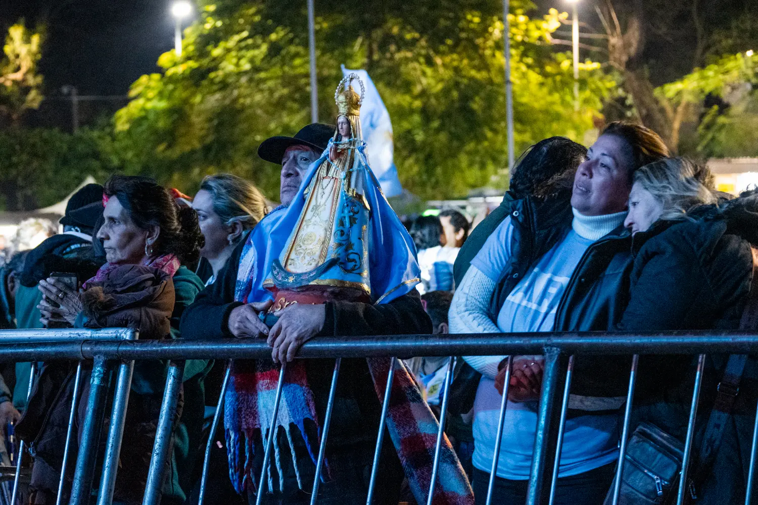 En la plaza, la Virgen de Itat&iacute; se multiplica por miles: est&aacute; en los banderines de pl&aacute;stico que flamean con la brisa, en las estampitas gastadas y, sobre todo, en las r&eacute;plicas de yeso que los fieles cargan a upa, abrazadas contra el pecho como si fueran ni&ntilde;os peque&ntilde;os. No importa el peso tras d&iacute;as de peregrinaci&oacute;n; esas im&aacute;genes son el ancla que une a las familias con este suelo.
