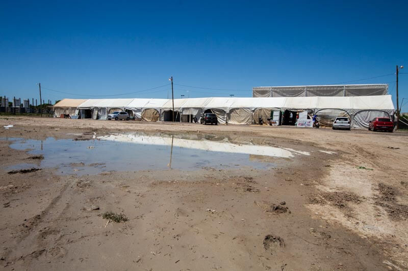 El enorme predio destinado a la carpa se encuentra aún con grandes charcos de agua, que dejó la lluvia del viernes; los vendedores reclaman mejoras para evitar otra inundación en sus locales.