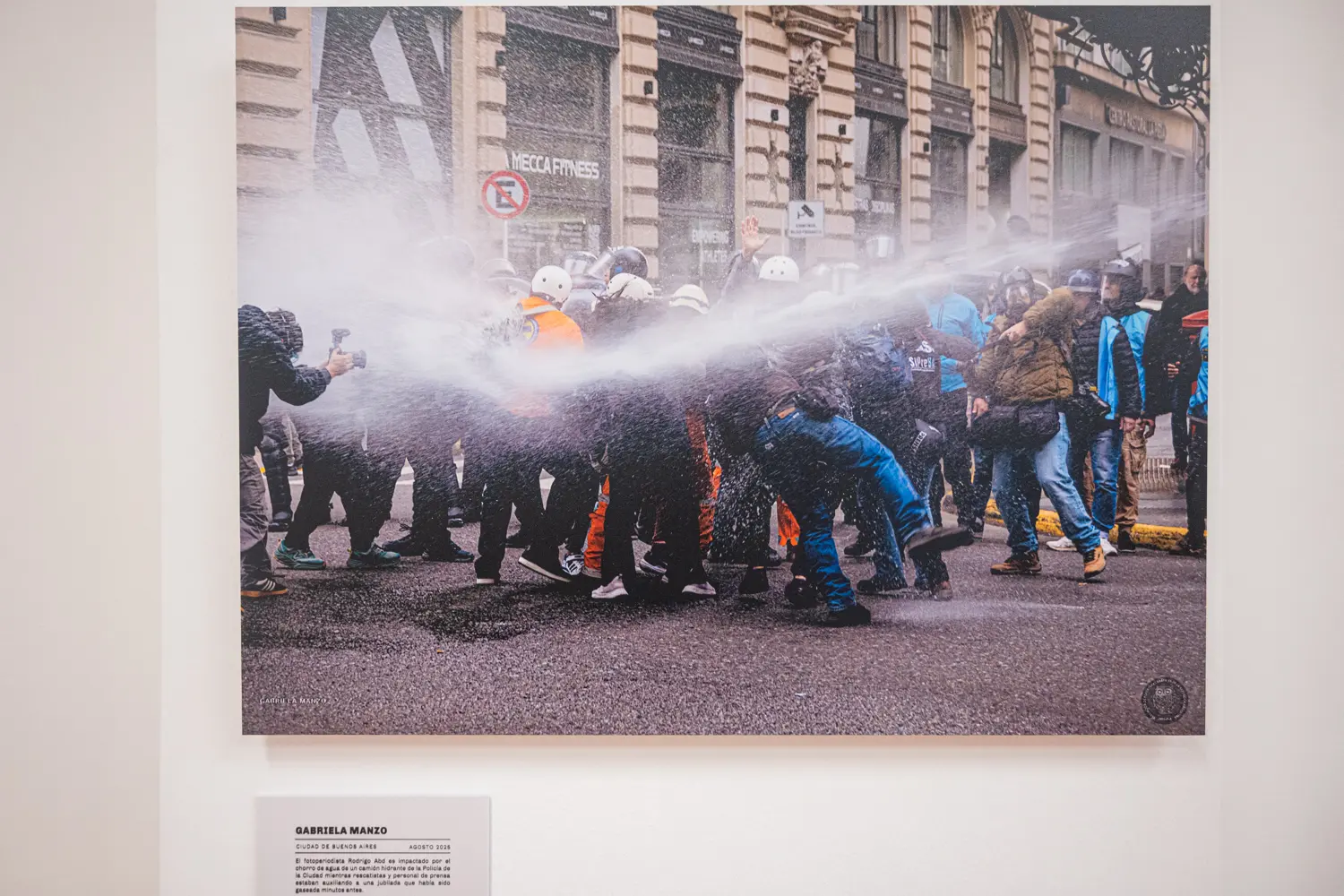 Una de las fotografías expuestas muestra a un trabajador de prensa en medio de una cobertura. La imagen recuerda que el registro periodístico no ocurre desde afuera de los acontecimientos: muchas veces implica permanecer allí mientras los hechos se desarrollan.