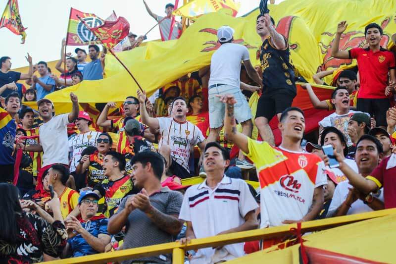 La hinchada aurirroja se hace presente en su propia cancha, alentando a su equipo a todo pulmón. La pasión y la fidelidad de los seguidores se manifiestan en la entrega total durante los 90 minutos del partido. 