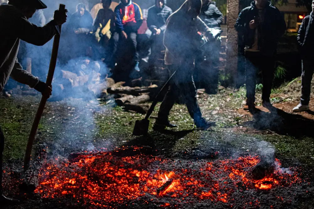 Cuando las llamas disminuyen, las brasas toman el protagonismo. Su preparaci&oacute;n marca el paso hacia uno de los desaf&iacute;os m&aacute;s antiguos y esperados de la celebraci&oacute;n.
