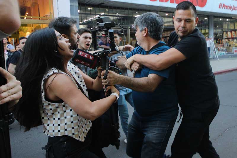 Custodios reducen a un camarógrafo durante los hechos de violencia. 